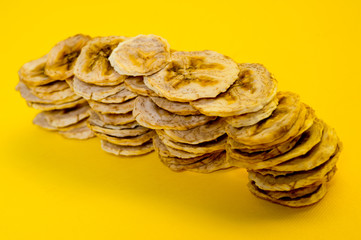 Dried banana chips, sliced in thin circles. Background for healthy and natural nutrition.