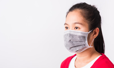 Asian adult woman wearing red shirt and face mask protective against coronavirus or COVID-19 virus or filter dust pm2.5 and air pollution she looking side, studio shot isolated white background