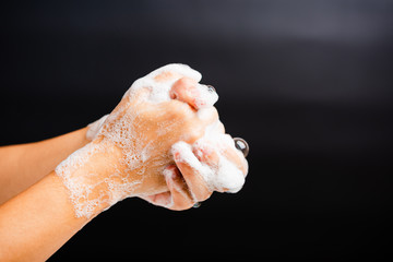 Closeup body care Asian young woman washing hands with soap have foam, hygiene prevention COVID-19 or coronavirus protection concept, isolated on black background