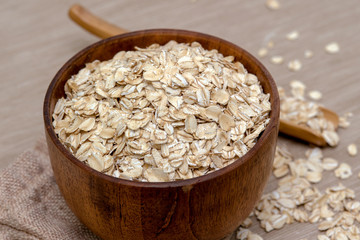 oatmeal in a wooden spoon and Cup, on a cloth.