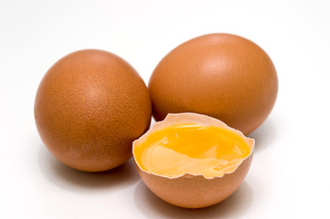 three eggs, one broken egg, egg yolk, isolated on a white background