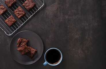 Brownies with Black coffee on dark table and Stainless cooking rack