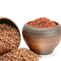 Lentils and brown rice in clay pots isolated on white background. Nutritious vegan food.