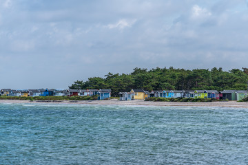 Fototapeta na wymiar Row of colorful cabins at the beach of Skanor in Sweden