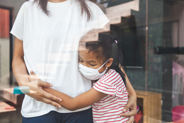 Fototapeta premium Asian child girl wearing protection mask hugging her mother and stay at home quarantine from the coronavirus Covid-19 and air pollution pm2.5.