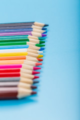Close-up of set of colorful pencils on blue background with copy space