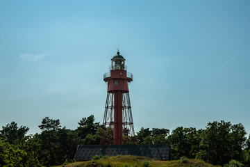 A modern lighthouse rising up against a blue summer sky