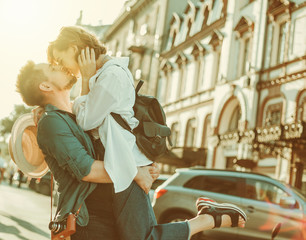 Cheerful cheerful hipster couple in love kissing at city. The romantic concept of lovers. love story