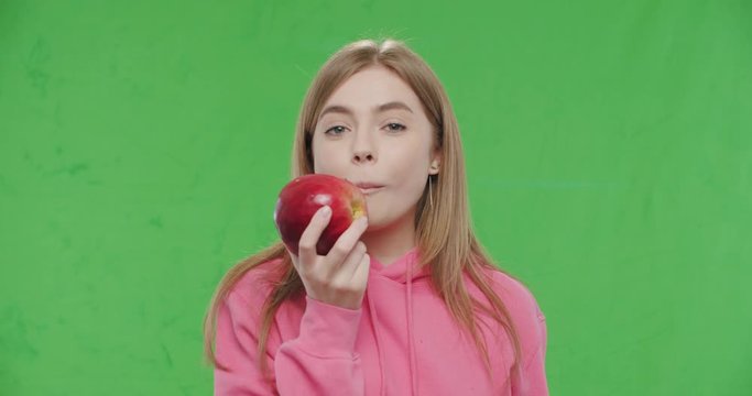 woman biting big fresh red apple