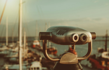 City binoculars on the background of the club yachts