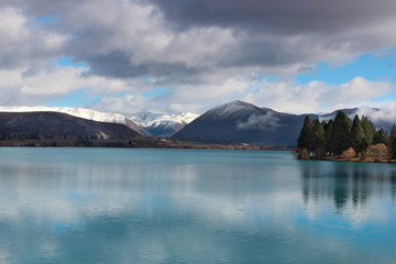 Snow capped mountains on the lake. Wintery landscapes of Otago, New Zealand.  