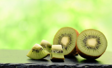 Kiwi fruits ripe cutted off selectiv focus isolated on blurred green background