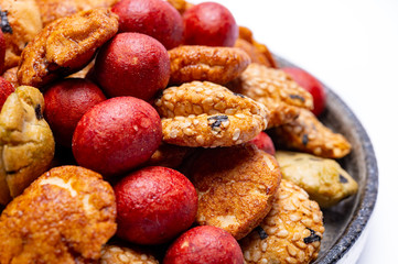 Tasty asian vegetarian appetizer, crunchy rice en peanuts snacks from Japan close up on white backgound