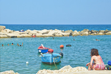 A tourist observes the horizon on the sea of Molfetta in Puglia