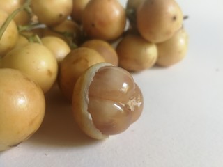 Baccaurea motleyana, a sweet, sour Thai yellow fruit on a white background.