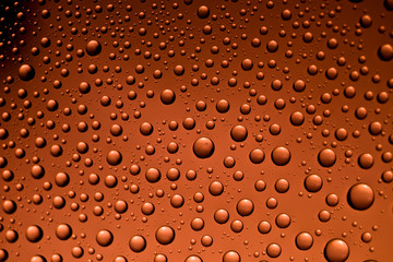 Background from drops of the different size on red glass with the vignette