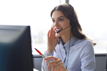 Woman customer support operator with headset and smiling.