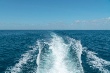 Ship Sailing on Ocean. Waves from the back of a speed boat over the water's surface in sea. View from the back of a ship