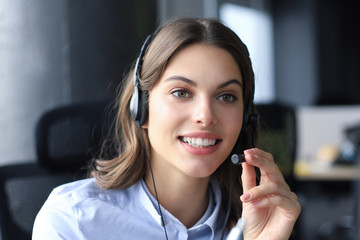 Female customer support operator with headset and smiling.