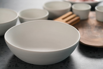 Empty matt white ceramic handmade tableware set on concrete countertop