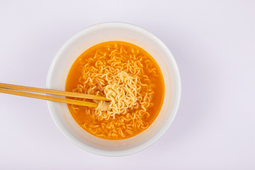 A bowl of cooked instant noodle curry taste on white background.