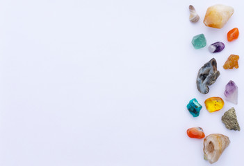 A scattering of semiprecious stones and gems, healing minerals and magic crystals on a white...