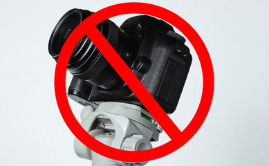 Prohibit photography. Camera with a tripod on gray background with prohibition sign