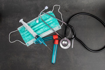 The vaccine and a hypodermic syringe with other medical equipment on black background. 