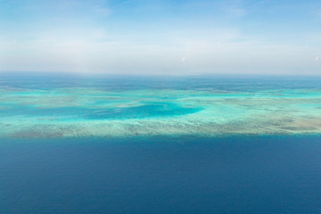 Great Barrier Reef Blue Ocean Sea view. Beautiful aqua & turquoise waters, with coral reef patterns in the ocean. View from helicopter, on vacation. Marine life, global warming, protection, island