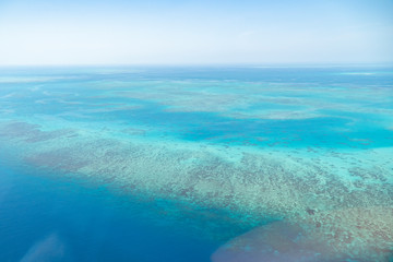 Great Barrier Reef Blue Ocean Sea view. Beautiful aqua & turquoise waters, with coral reef patterns in the ocean. View from helicopter, on vacation. Marine life, global warming, protection, island