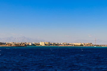 Naklejka na ściany i meble Beautiful view of the coastline with houses and hotels in Hurghada, Egypt. View from Red sea