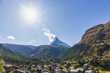 The Matterhorn mountain peak and valley with Zermatt village switzerland in summer under sun glare...