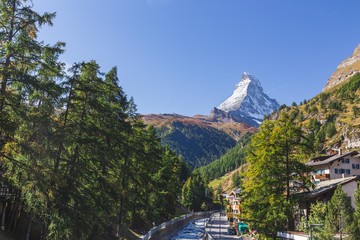 Landscape of Matterhorn mountain peak view from Kirchbrucke bridge with row of green pine tree and...
