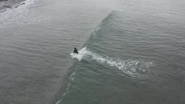 A lone surfer awaits the wave of Playa de Las Americas