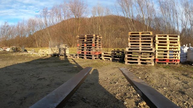 Forklift picking up stack of pallets