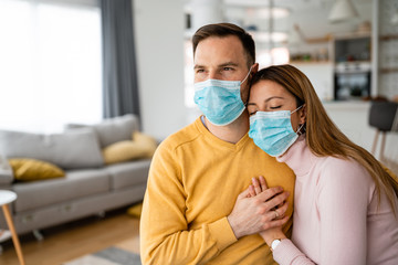 Home isolation during coronavirus quarantine. Man and woman wearing face mask. Stay home.