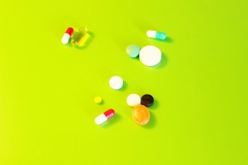 Pills vitamins medicines located on a green background