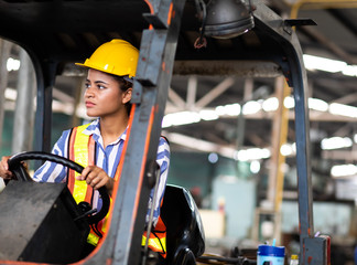 African american Woman forklift worker operator driving vehicle wearing safety goggles and hard hat at warehouse