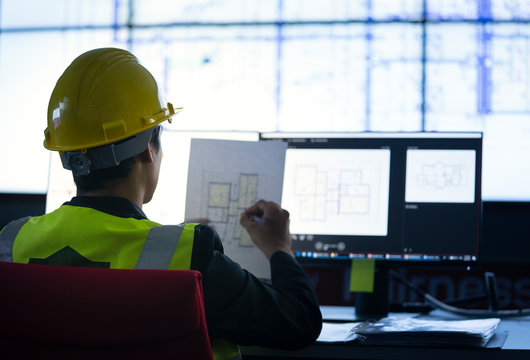 Industrial Engineering works in front of monitoring screen in the  control center office. technology and artificial intelligence concept.