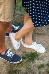 Young couple in love stading cross-legged outdoor in nice sunny da