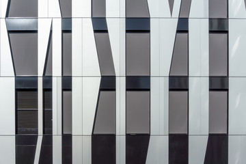 Detail of a modern office building with decorative facade panels of irregular shapes. Architecture photography.