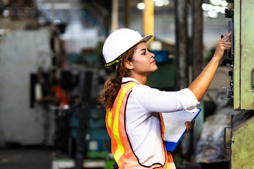 Manufacturing Factory female Mechanical Engineer Works on Personal Computer at Metal lathe industrial manufacturing factory. Factory Engineer Operating  lathe Machinery