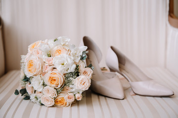 Bridal morning details composition. Top view of wedding rings, beautiful bouquet of pink flowers with ribbons, boutonniere and leather shoes. Flat lay.
