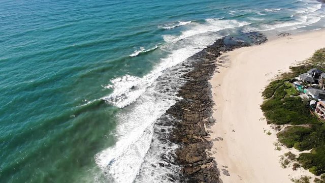 Stunning seascape of Jeffreys Bay. Aerial rising, tilt down