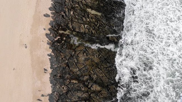 Beautiful seascape with supertubes towards rocks. Aerial birds eye, rising