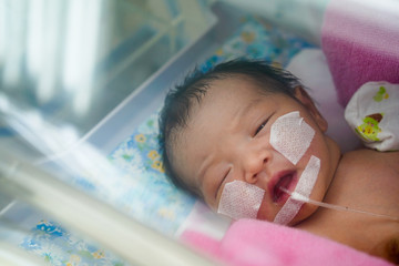 Asian patient newborn baby in the hospital is having a medical treatment in NICV after received   a Covid-19 or Corona virus.