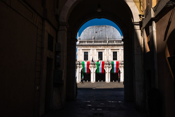 Brescia (Italy) - 04/25/2020: 75th anniversary of the Liberation Day from the fascist dictatorship. Unusual point of view of the Palazzo della Loggia (Loggia Palace - Town Hall), framed in an archway.
