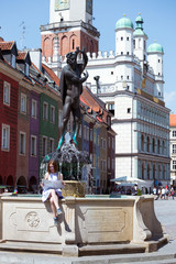 Fototapeta premium girl looking at the map sitting by the fountain