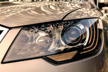 Headlight of modern prestigious car close up. Car headlight with shallow depth of field.