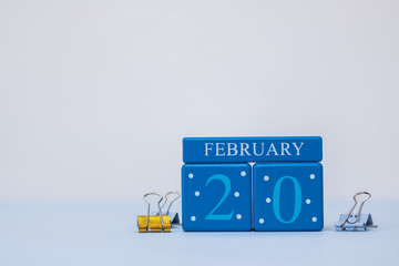 A calm office scene with calendar date blue blocks February 20 and metal clips